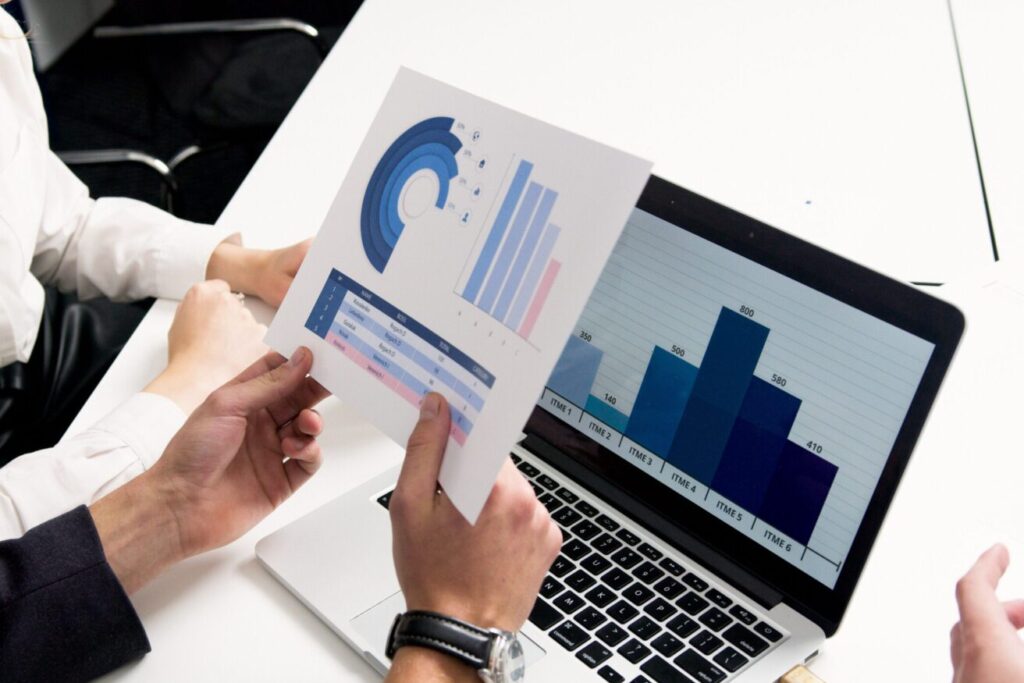 Business professionals discussing data charts and graphs in a modern office setting.